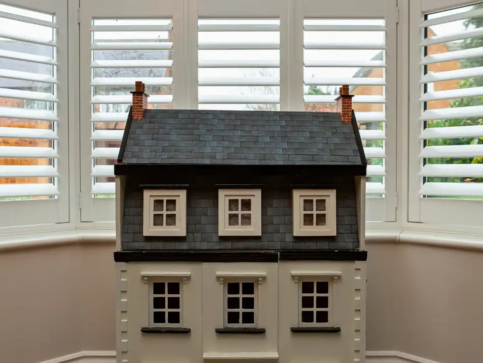 Bay window shutters above a dolls house window seat
