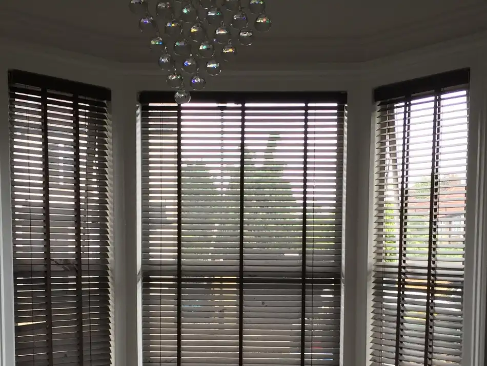 White wooden venetian blinds on a sunny windowsill